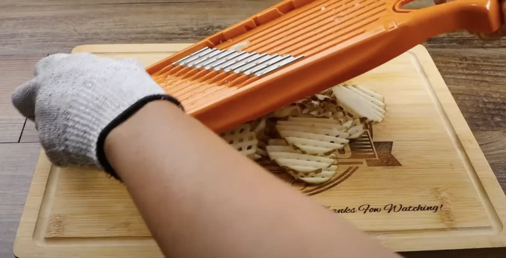 slicing the potatoes to make waffle fries